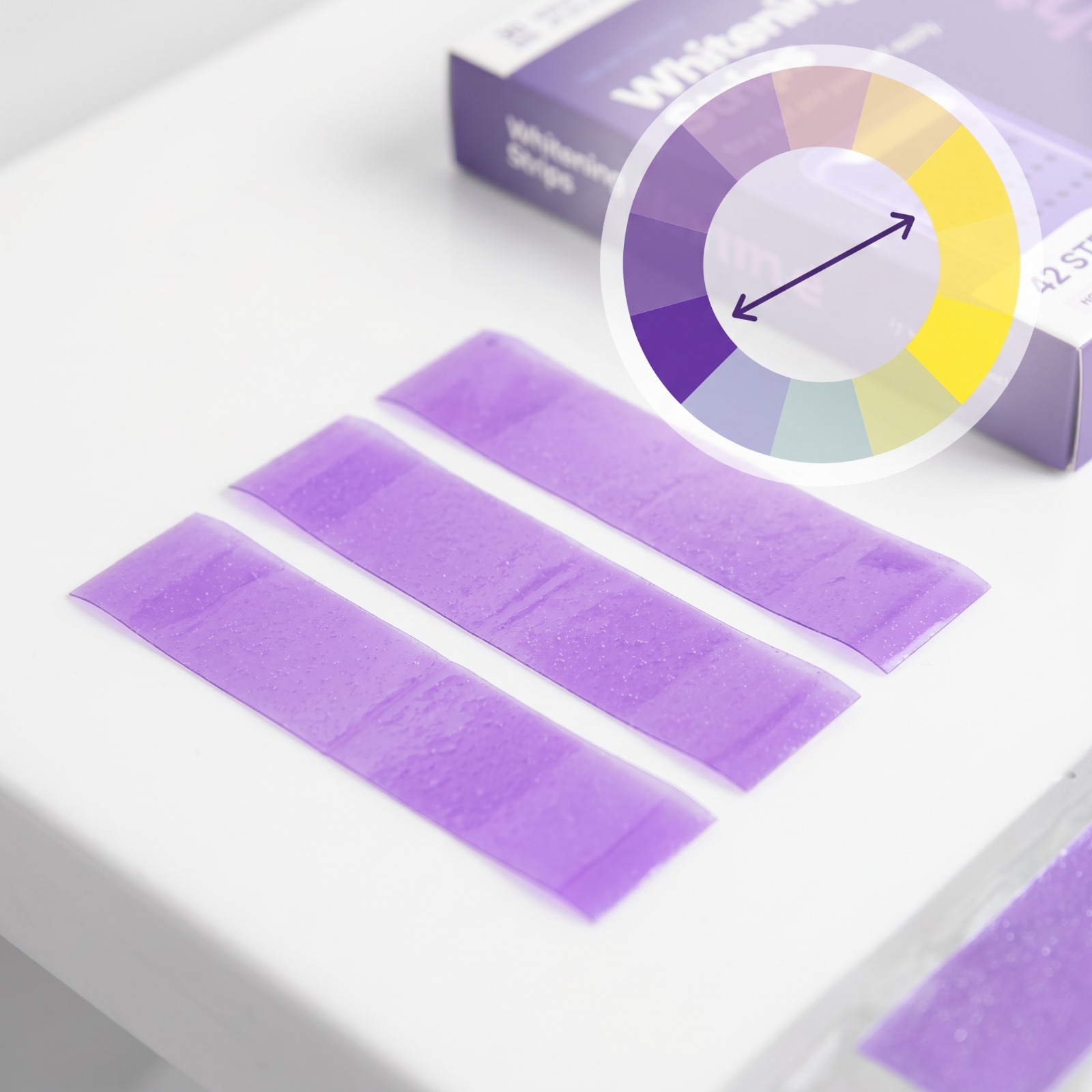 Clean product close-up of purple whitening strips against a white background with a subtle color wheel graphic
